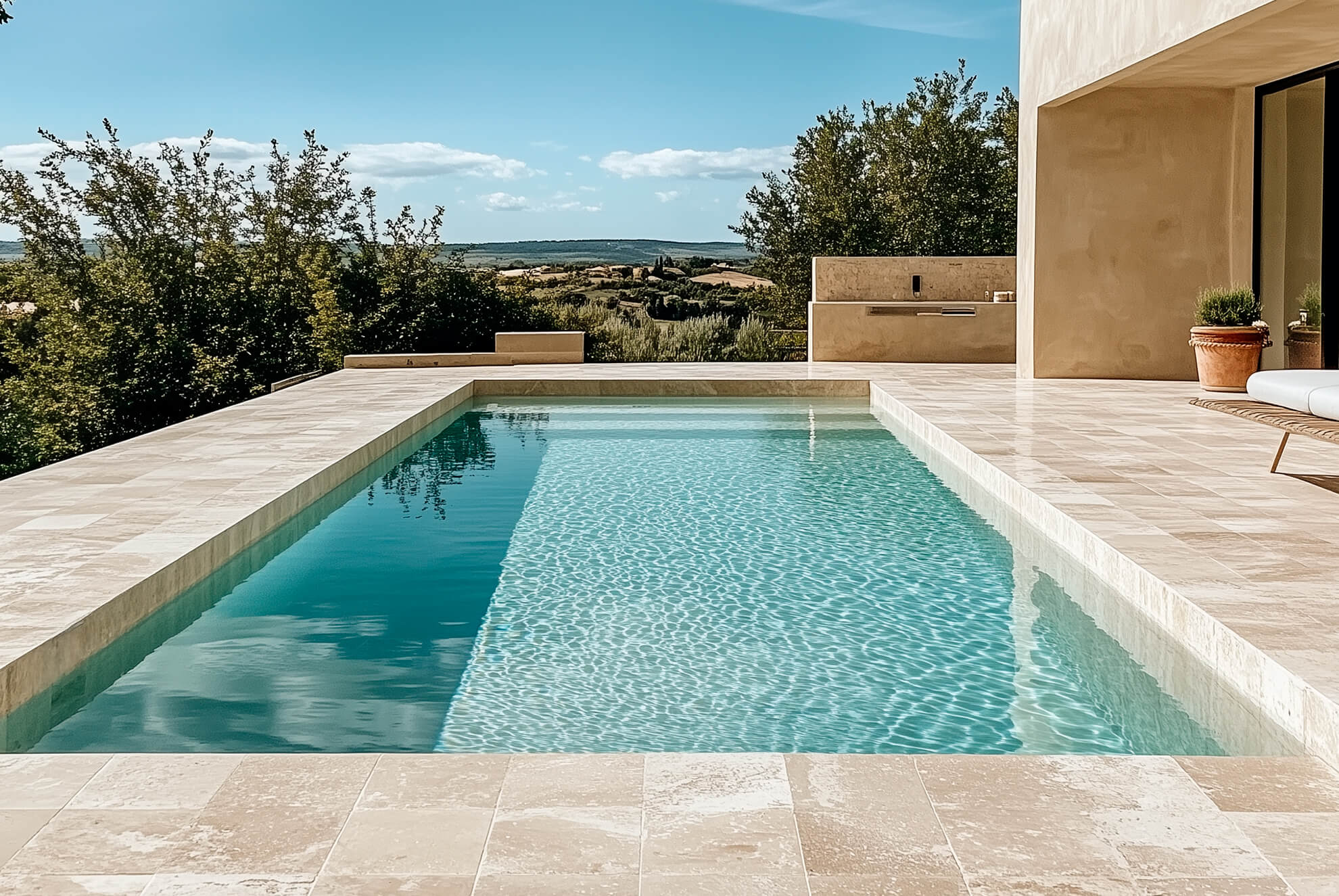 Piscine rectangulaire raffinée, réalisée avec des margelles en travertin, pour un style à la fois naturel et élégant